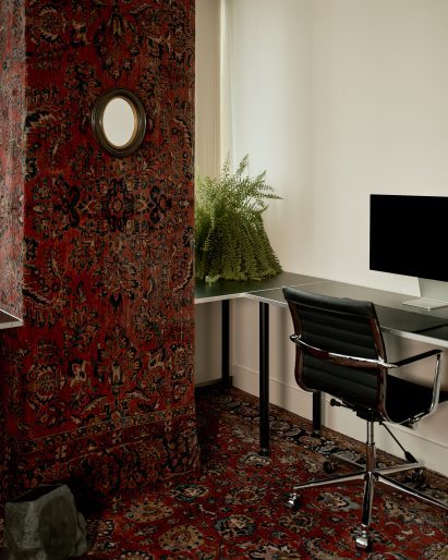 Structural column in an office wrapped in Persian rugs
