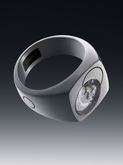 Image of the signet ring-like Quartz ring showing a quartz stone embedded on the top, a sensor inside the band and a small button on the side