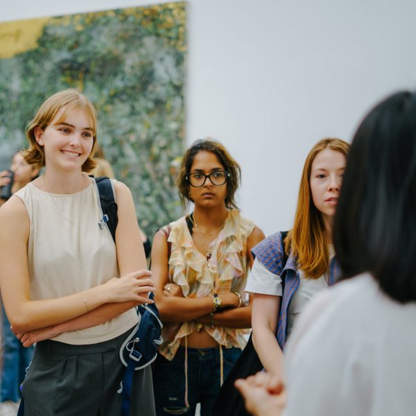 people standing in front of artwork in a gallery