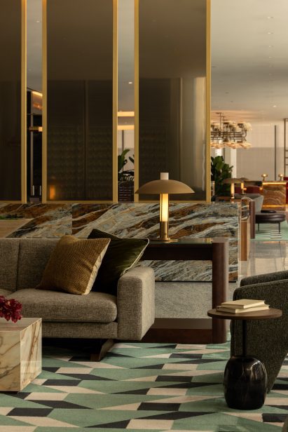 Office amenity lounge with a geometric carpet and mid-century-inspired furniture