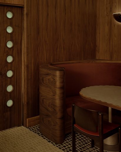 A restaurant corner with a scalloped-top table and frosted-glass inserts in the kitchen door