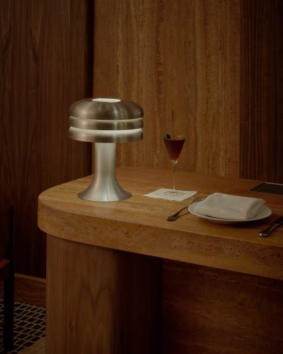 A Hans-Agne Jakobsson table lamp sits atop a red travertine bar