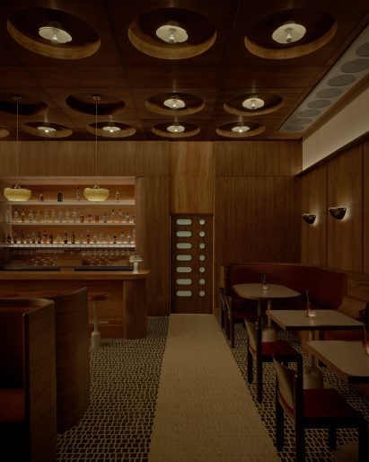 Restaurant interior with walnut-panelled walls and ceiling grid