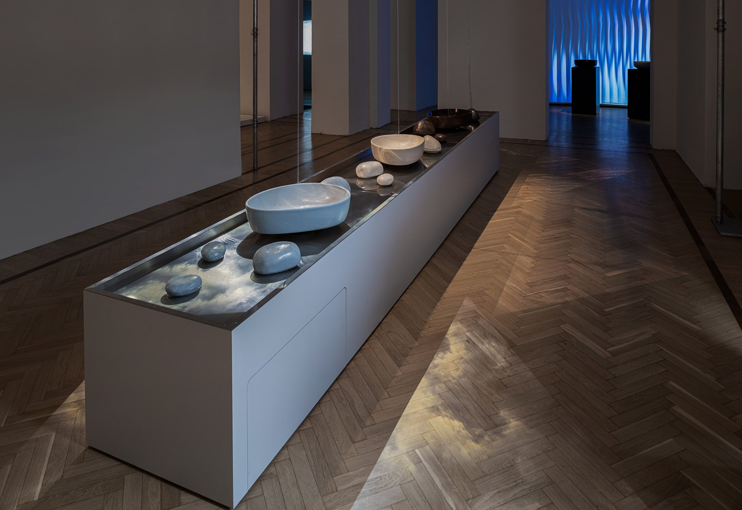 Long display table with ceramic basins and stones