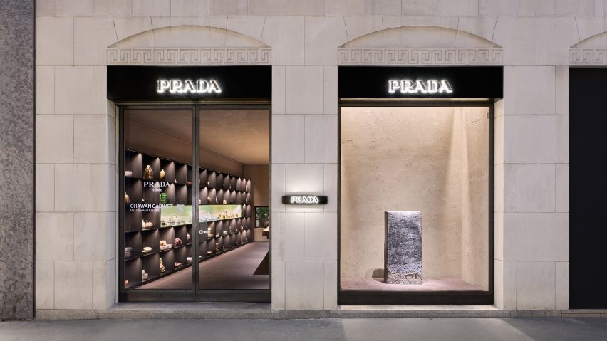 Photo of the Prada Home shopfront in Milan showing glimpses of the Chawan Cabinet pottery exhibition beyond the glass doors and a single large sculptural object in the window against a calming creamy-coloured backdrop