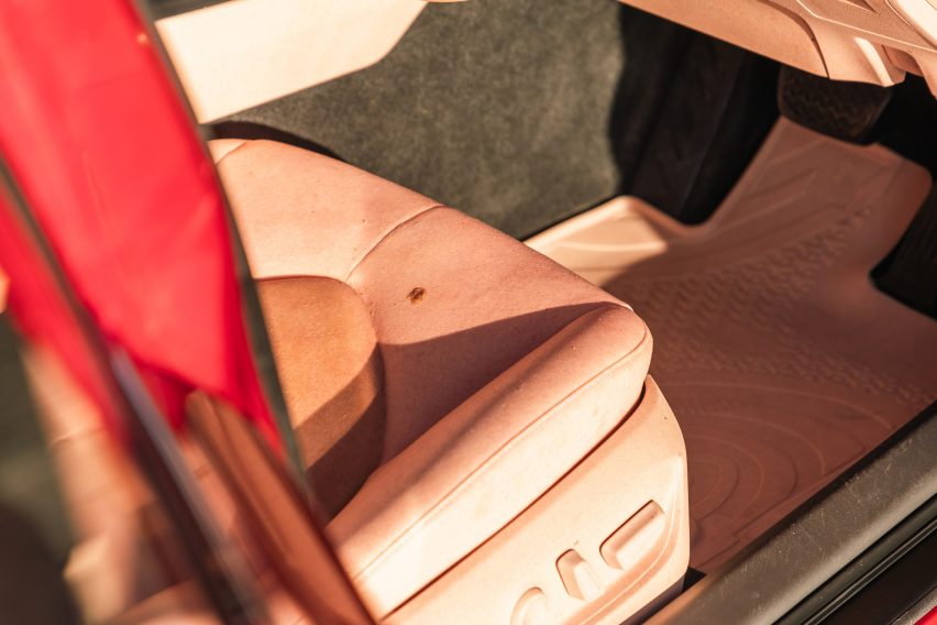 Close-up photo of a seat inside The Sunburnt Car, showing it neatly upholstered in two tones of human-like "skin", one pinkish the other more brown