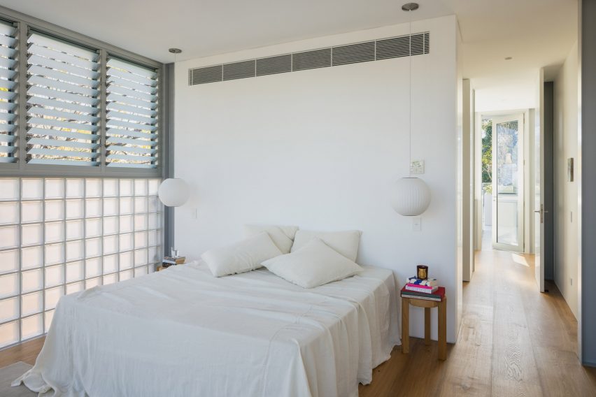 White bedroom with glass brick wall