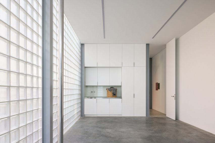 Garage with glass brick outer wall and cement floor