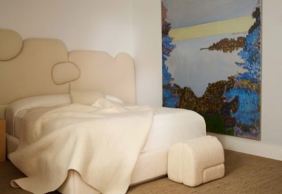 Studio Ahead's Sheep bed and ottoman sit beside a large oceanscape painting