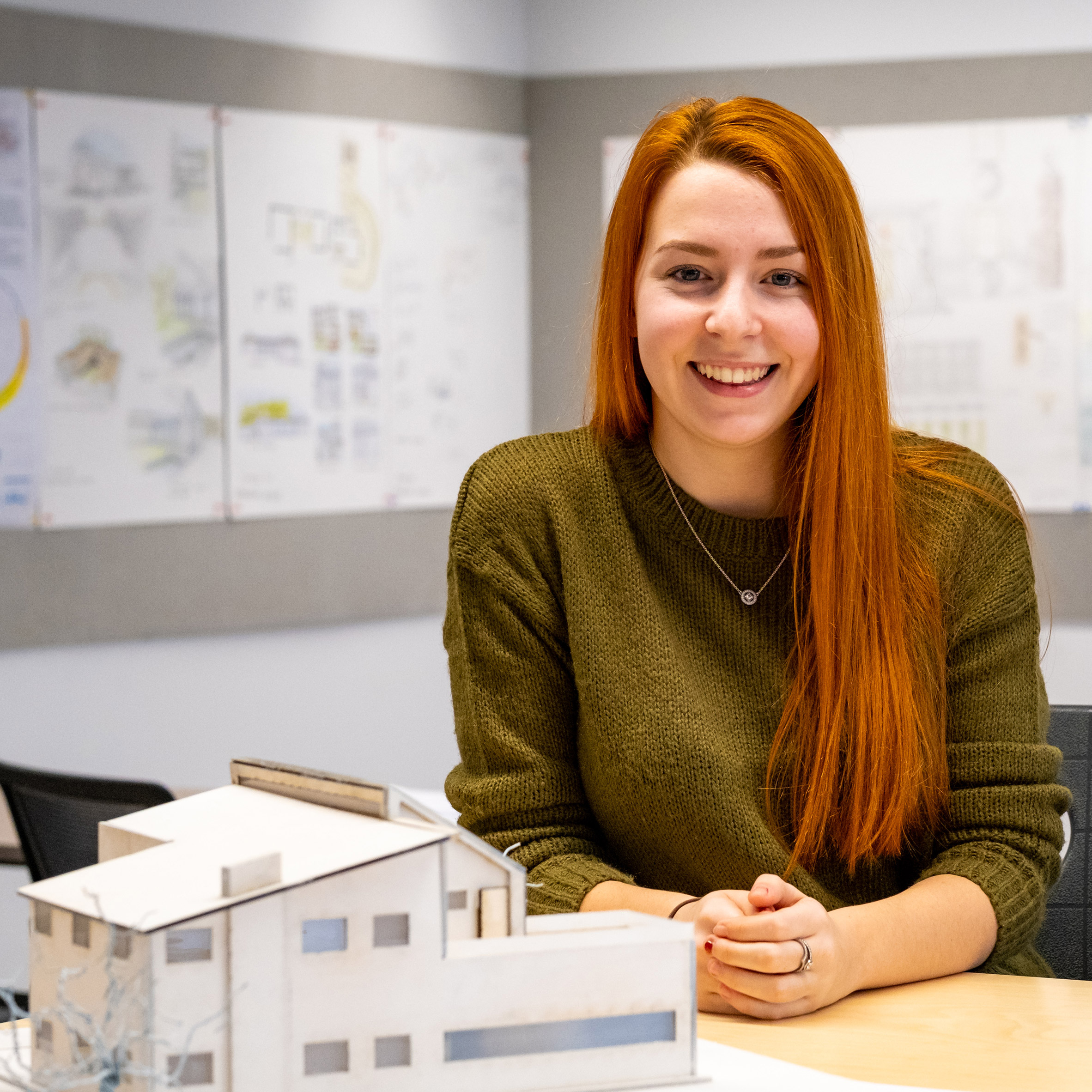 a person with an architecture model next to them