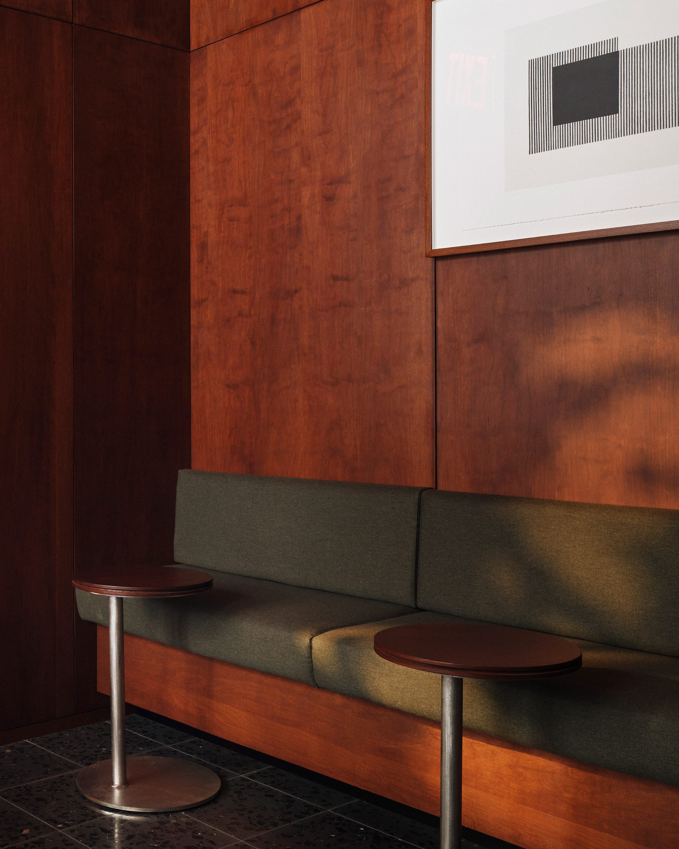 A cushioned banquettes wrapped in forest green upholstery