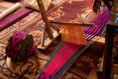 Handweaving loom with brightly coloured threads used in Uzbek textile production
