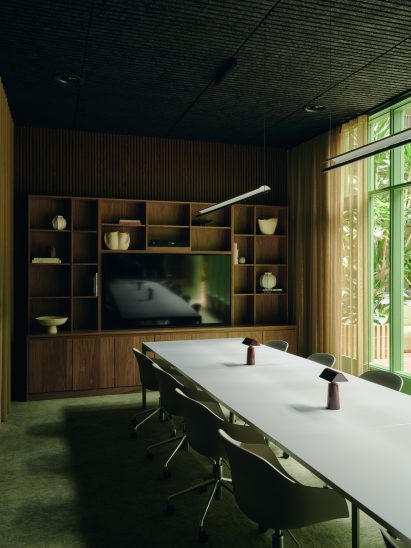 Long desk in room with green floor