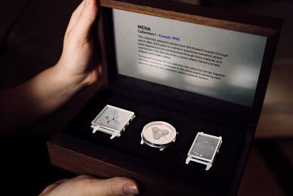 Image of a person opening a box with three silver watch faces, all of a different shape.