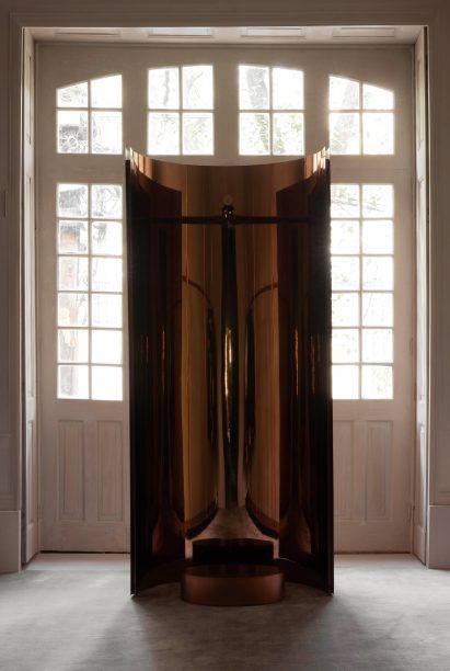 A mirrored concave stand is centred in front of a large window