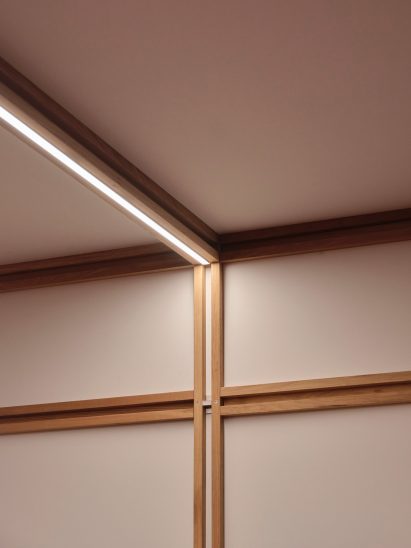 Close-up photo of the framework joining at the ceiling of the QuadroDesign booth at Salone 2026, with a lighting strip embedded in a cavity of the ceiling beam