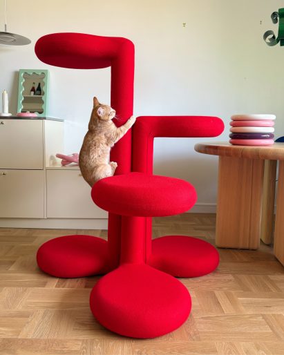 Cat climbing red cat tree