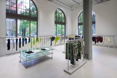 A continuous garment rail spans across grand arched windows