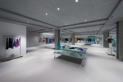 A store's mezzanine level with garments displayed on aluminium racks and tables