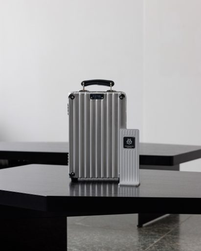 Rimowa suitcases and award trophies displayed on black tables