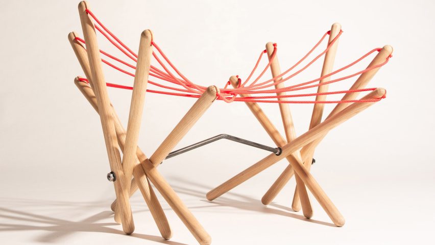 a sculptural stool made from wood and red string