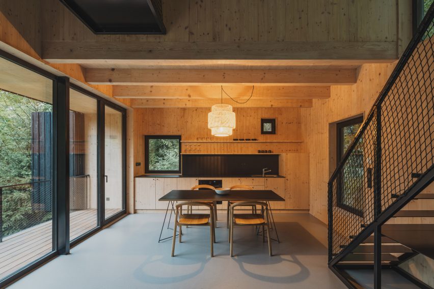 Dining and kitchen area of log cabin in forest