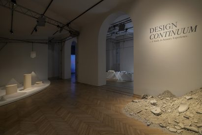 Ceramic debris arranged beneath the Design Continuum exhibition title inside the Milan showroom