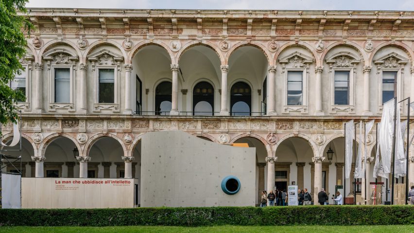 Tile-clad structure in front of ornate building