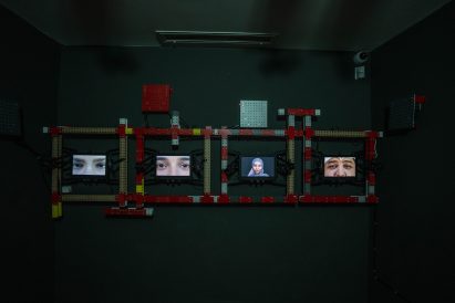 Photo of an exhibition with close up images of people's faces