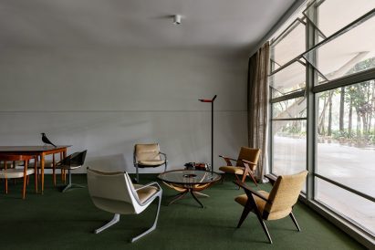 A display of modernist Brazilian furniture in a green-carpeted room