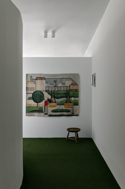 A tapestry by Brazilian artist Tarsila do Amaral adds color to a white wall