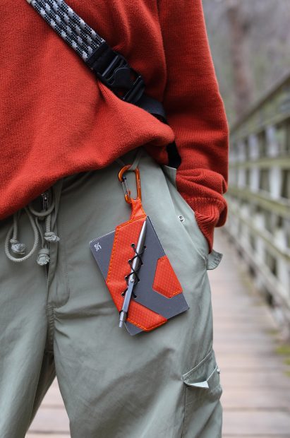 image of a red and black notebook clipped onto trousers