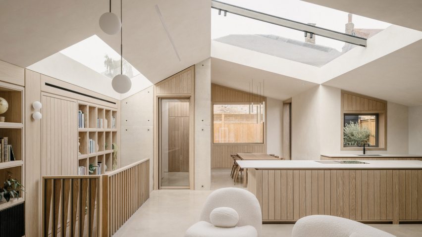 Living room and kitchen at Green Lodge featuring oak joinery, exposed concrete walls and rooflights