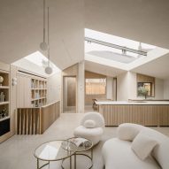 Living room and kitchen at Green Lodge featuring oak joinery, exposed concrete walls and rooflights