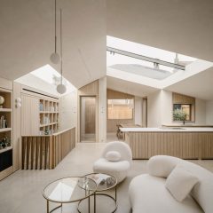 Living room and kitchen at Green Lodge featuring oak joinery, exposed concrete walls and rooflights