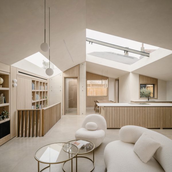 Living room and kitchen at Green Lodge featuring oak joinery, exposed concrete walls and rooflights
