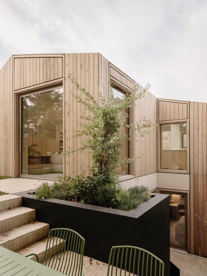 Outdoor terrace beside a planted lightwell, with steps leading to the upper level of the house