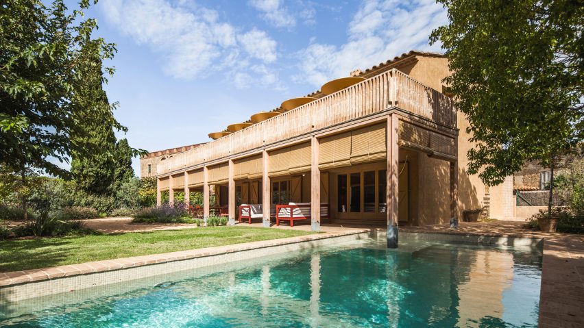 Exterior view of the house showing a timber porch extending alongside a swimming pool and garden