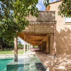 Timber porch with bamboo blinds extends over the edge of an existing swimming pool