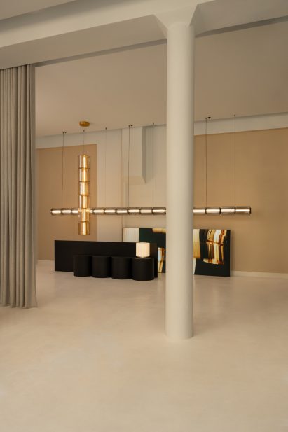 Minimal room with a large cross-shaped suspended lighting installation