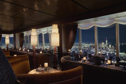Restaurant with tiered lighting and NYC skyline view