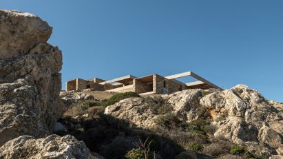 Stone-clad hospitality retreat embedded into a rocky hillside overlooking the Aegean Sea on Serifos