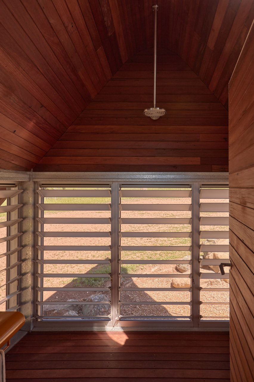 Bathroom view with louvred windows in cabin by Casey Brown architecture