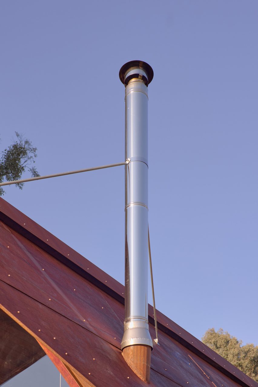 Steel chimney from pot belly stove in cabin by casey brown architecture