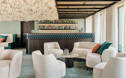 A lower-deck bar featuring pale green tones and a feathery ceiling