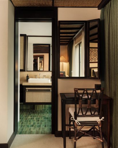 Locally sourced mahogany wood and green accents in a bedroom and bathroom