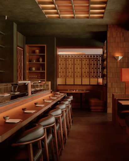 Sushi bar counter with mottled green walls and ceiling