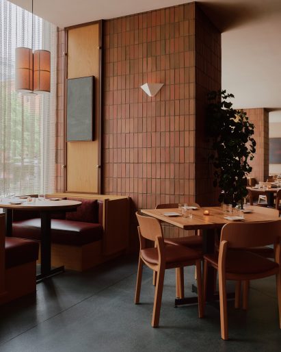 Straight-stack clay tiles wrap a large column and dark stone covers the floor
