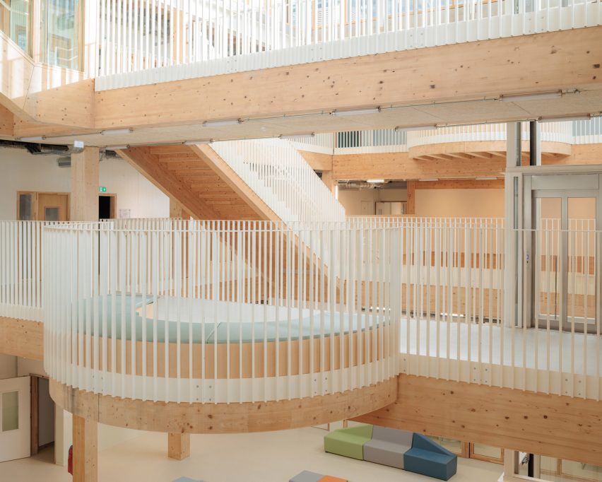 Timber-lined atrium with circular balcony and exposed structure