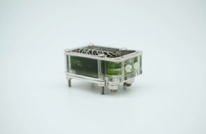 Photo of the University of Cambridge's algae biocell on its side showing a transparent domino-shaped case held together by thin metal plates and screws and filled with green goo